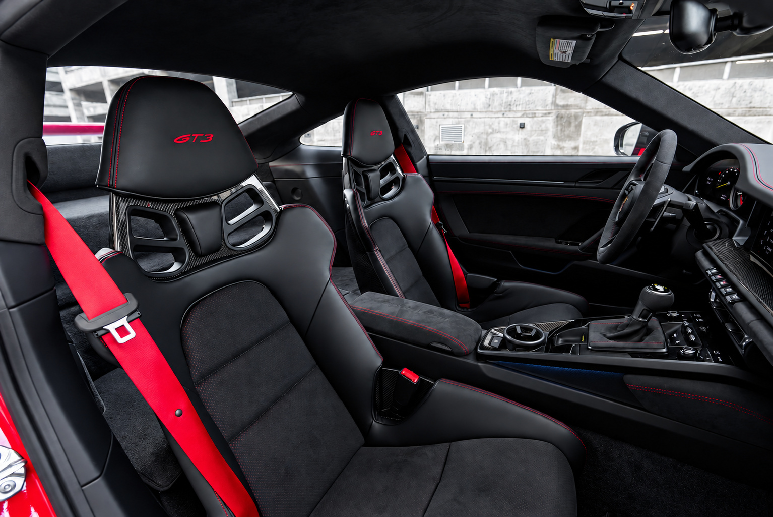 Carbon bucket seats in the Porsche 911 GT3 with red seatbelts and GT3 stitched into the headrests