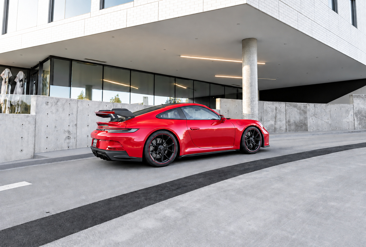 Rear three-quarter of the Guards Red Porsche 911 GT3 showing the swan-neck wing and black wheels