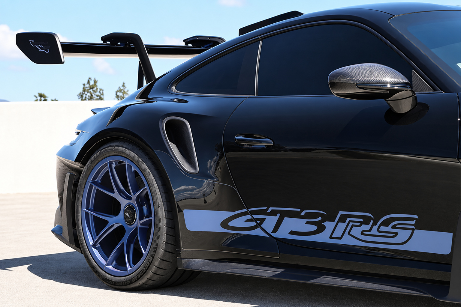 Blue magnesium wheel, front fender louvres and GT3 RS script on the black Porsche 911 GT3 RS Weissach