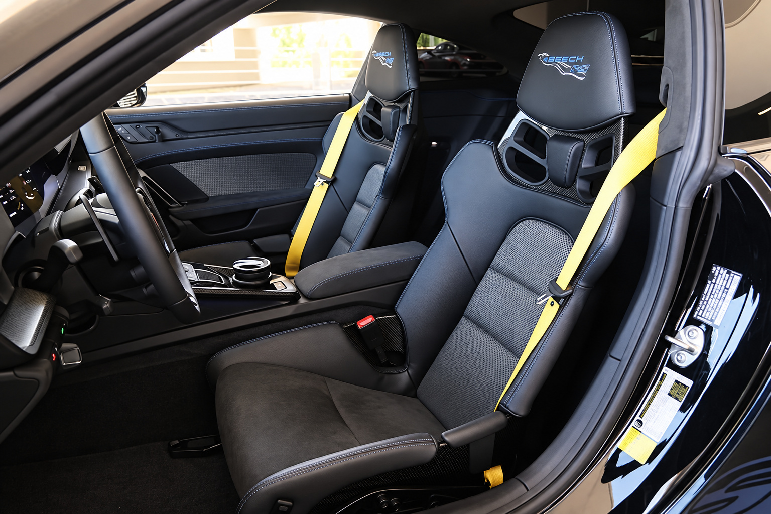 Carbon bucket seats with yellow seatbelts inside the black cabin of the Porsche 911 GT3 RS Weissach