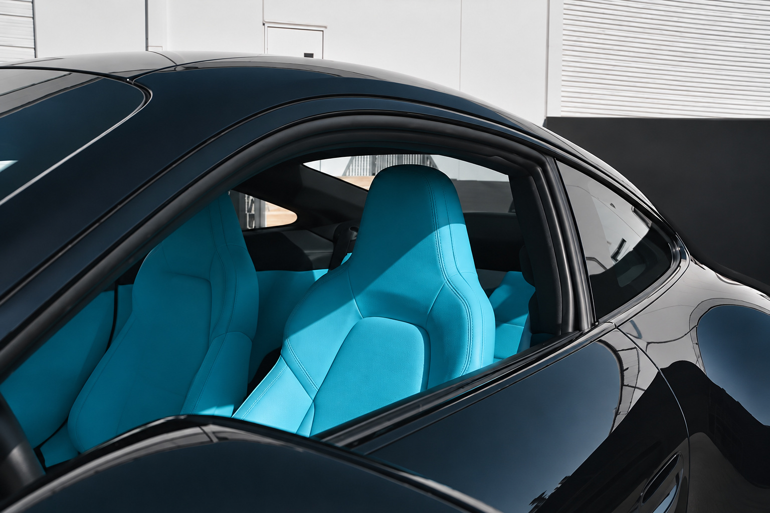 Miami Blue seats seen through the side window of the black Porsche 911 GT3 Touring