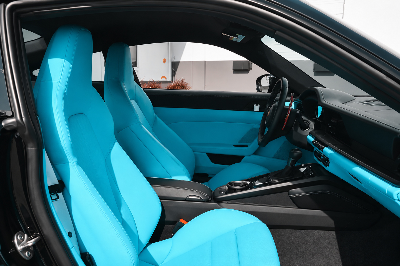 Full Miami Blue leather sport seats inside the Porsche 911 GT3 Touring with the door open