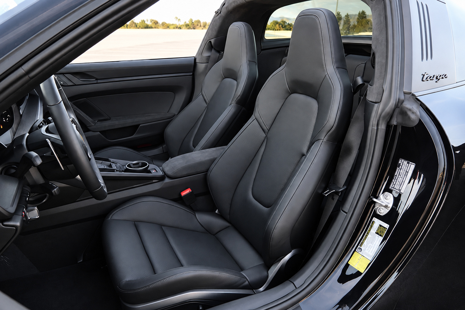 Black leather front seats of the Porsche 911 Targa 4 GTS with the targa script on the roof bar