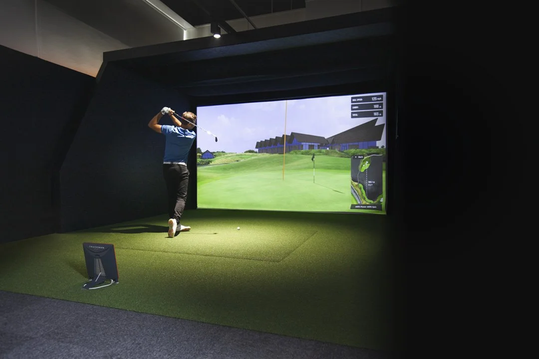 Golfer swinging in an indoor simulator
