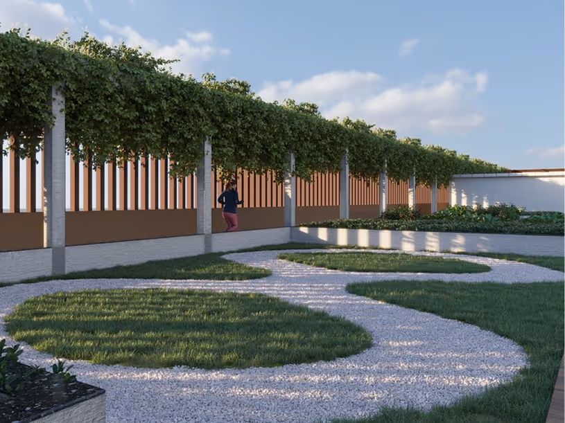 Garden area with gravel pathways forming circular patterns and grass sections, supported by pergola with green vines overhead and a person walking nearby.