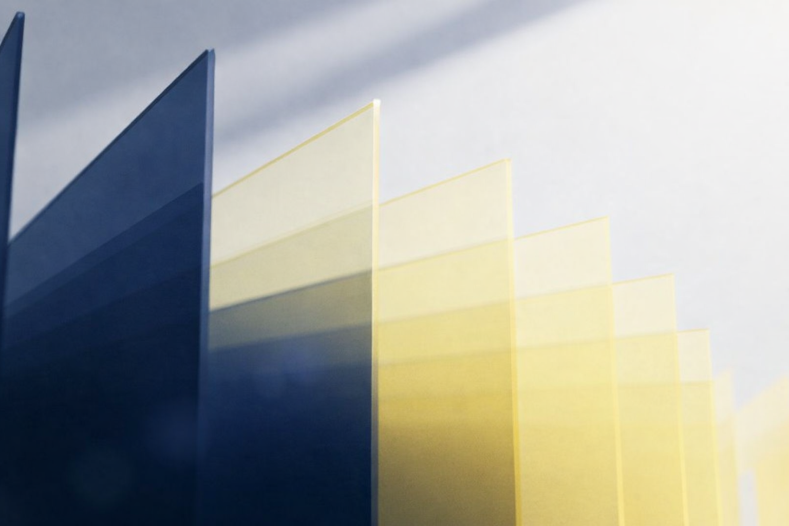 Stack of translucent blue and yellow rectangular sheets arranged in a staggered pattern.