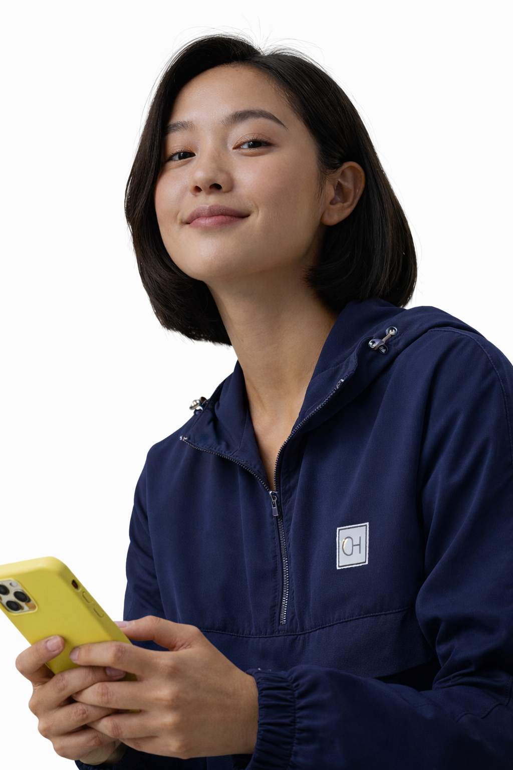 Woman in navy blue jacket holding a yellow smartphone, smiling confidently against a white background.