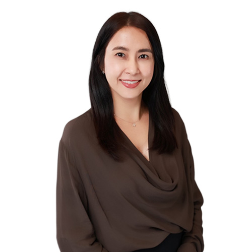 Smiling woman with long dark hair wearing a dark brown blouse on white background.