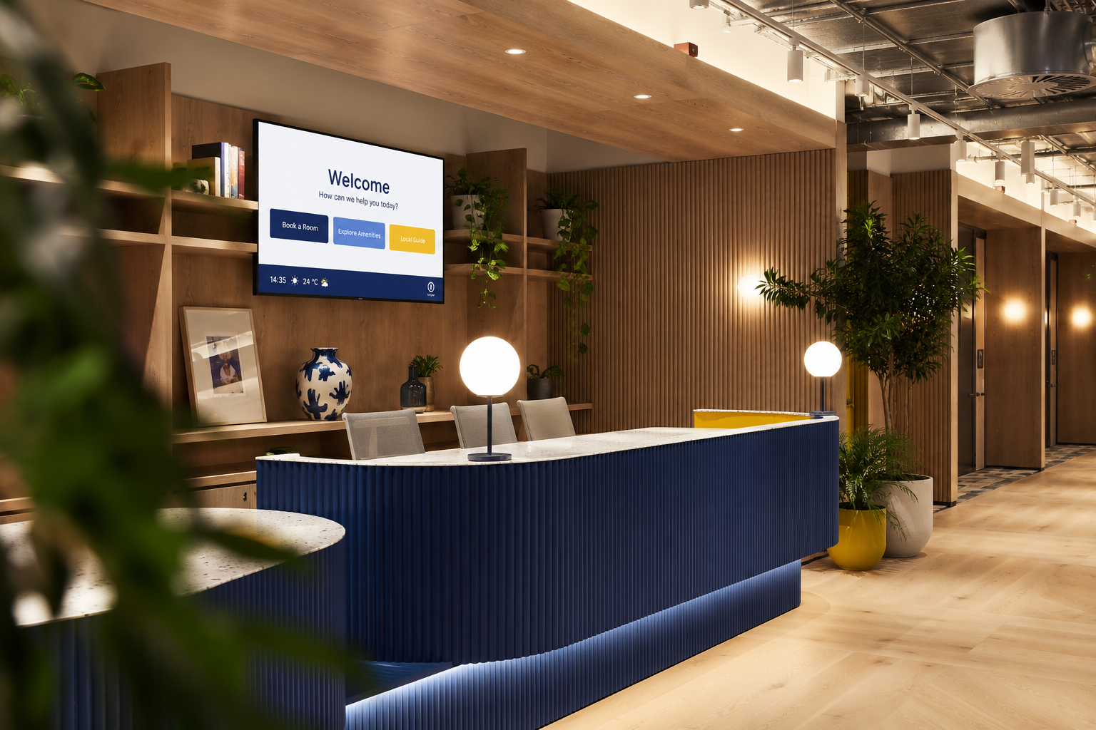 Modern hotel reception with blue desk, globe lamps, plants, and a wall screen showing a welcome message.