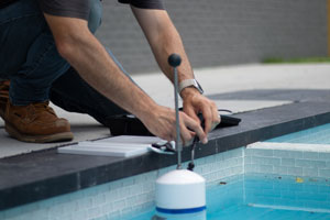a pool inspector conducting a computer leak analysis test with a leak computer