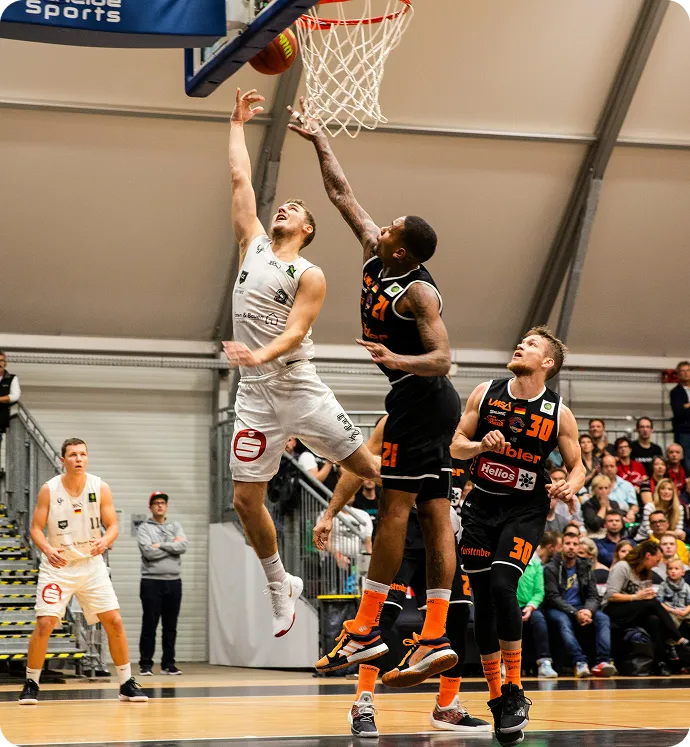 photographie de joeurs de basket entrain de marquer un panier