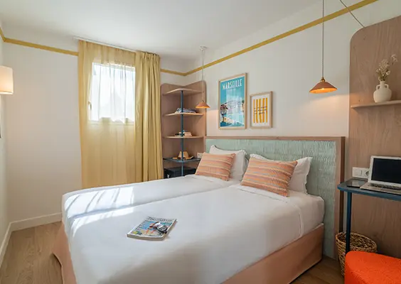Soléo Prado, chambre d’hôtel à Marseille avec lit double et petit bureau, pratique près de la place Castellane.