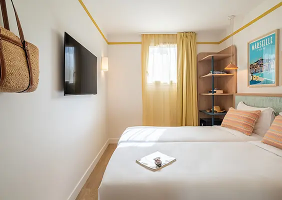 Soléo Prado, chambre d’hôtel à Marseille avec lit double, ambiance chaleureuse dans le quartier Prado près des plages.