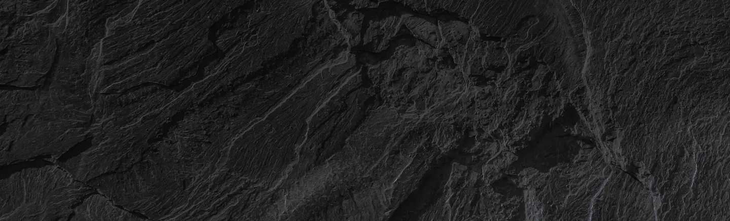 Textured black slate stone surface with natural veins and streaks.