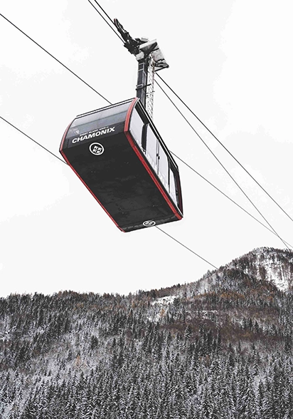 homme de dos face à la montagne enneigée heliopic chamonix mont-blanc