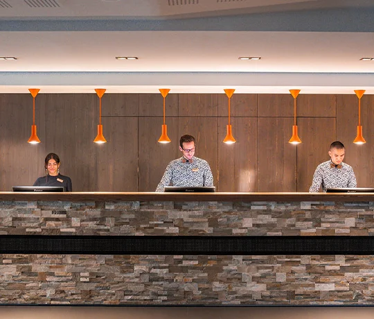Réception de l'Heliopic Hotel & Spa à Chamonix avec trois membres du staff