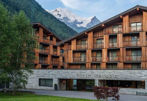 La façade de l'Heliopic Hotel & Spa à Chamonix au printemps, avec le massif du Mont-Blanc en arrière-plan.