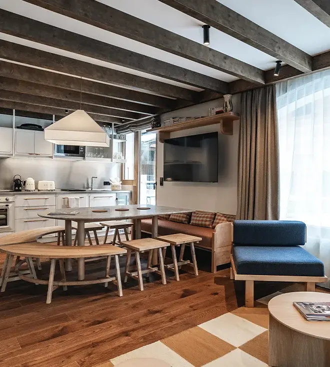 Appartements de la Maison Lyret avec un salon au design moderne et sobre ainsi qu'un espace cuisine aménagé avec une table à manger