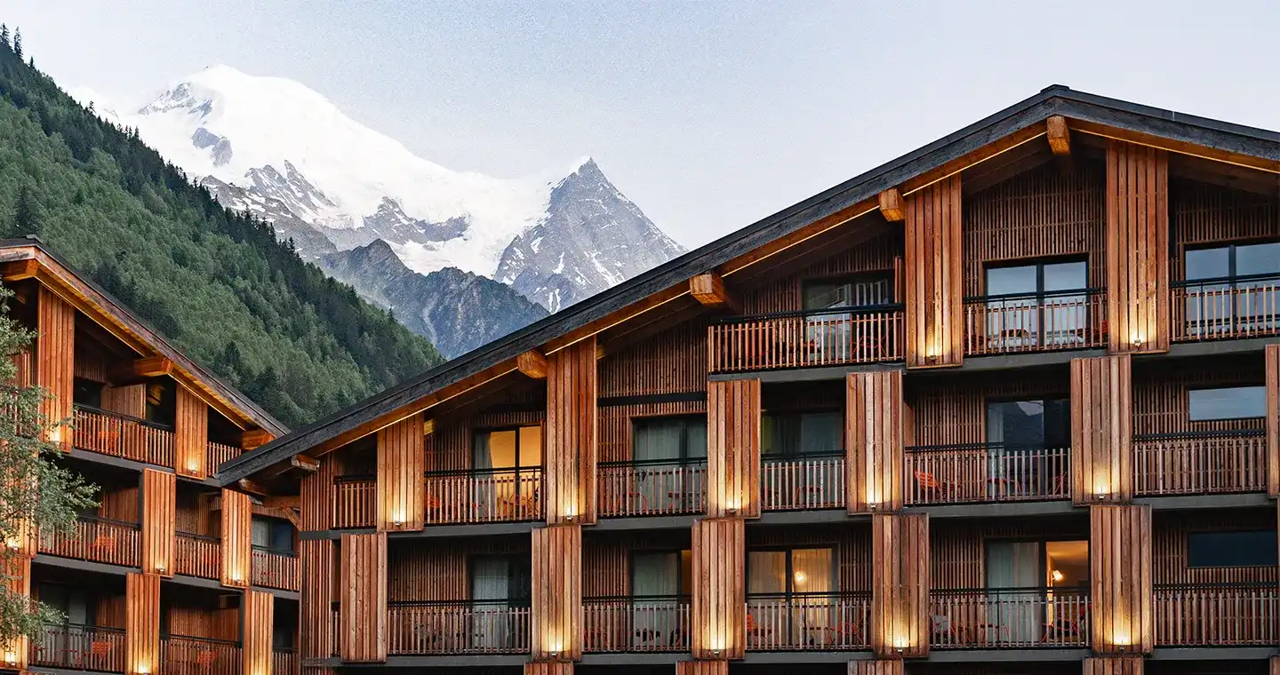 Façade de l'Heliopic Hotel & Spa à Chamonix de jour avec en arrière plan les premiers sommets du massif du Mont-Blanc