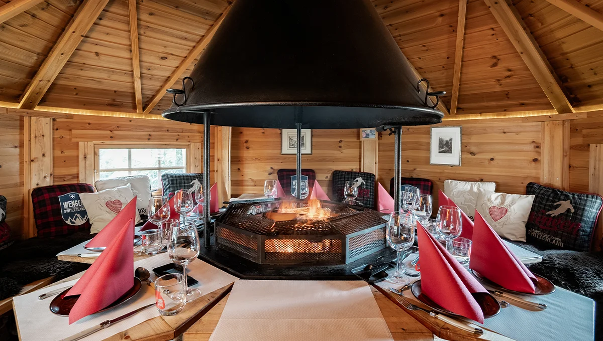 L'intérieur du Grillkota, typique d'un chalet en bois traditionnel suisse avec en son centre le foyer pour la raclette