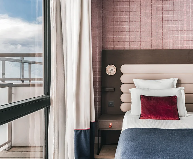 Une chambre classique de l'hôtel Marielle à Val Thorens avec un lit et une fenêtre donnant sur le domaine skiable de la station.