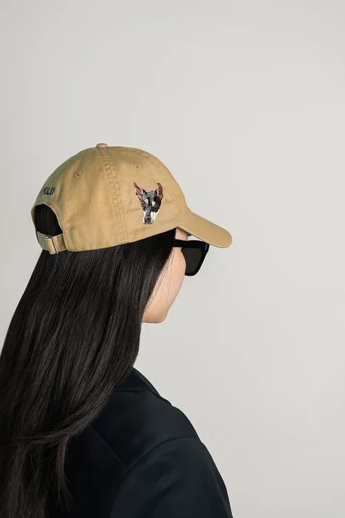 Tan baseball cap with an embroidered dog face on the side.