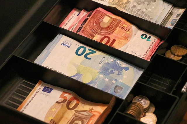 Tiroir-caisse ouvert avec billets en euros classés par valeur pour une gestion de caisse efficace