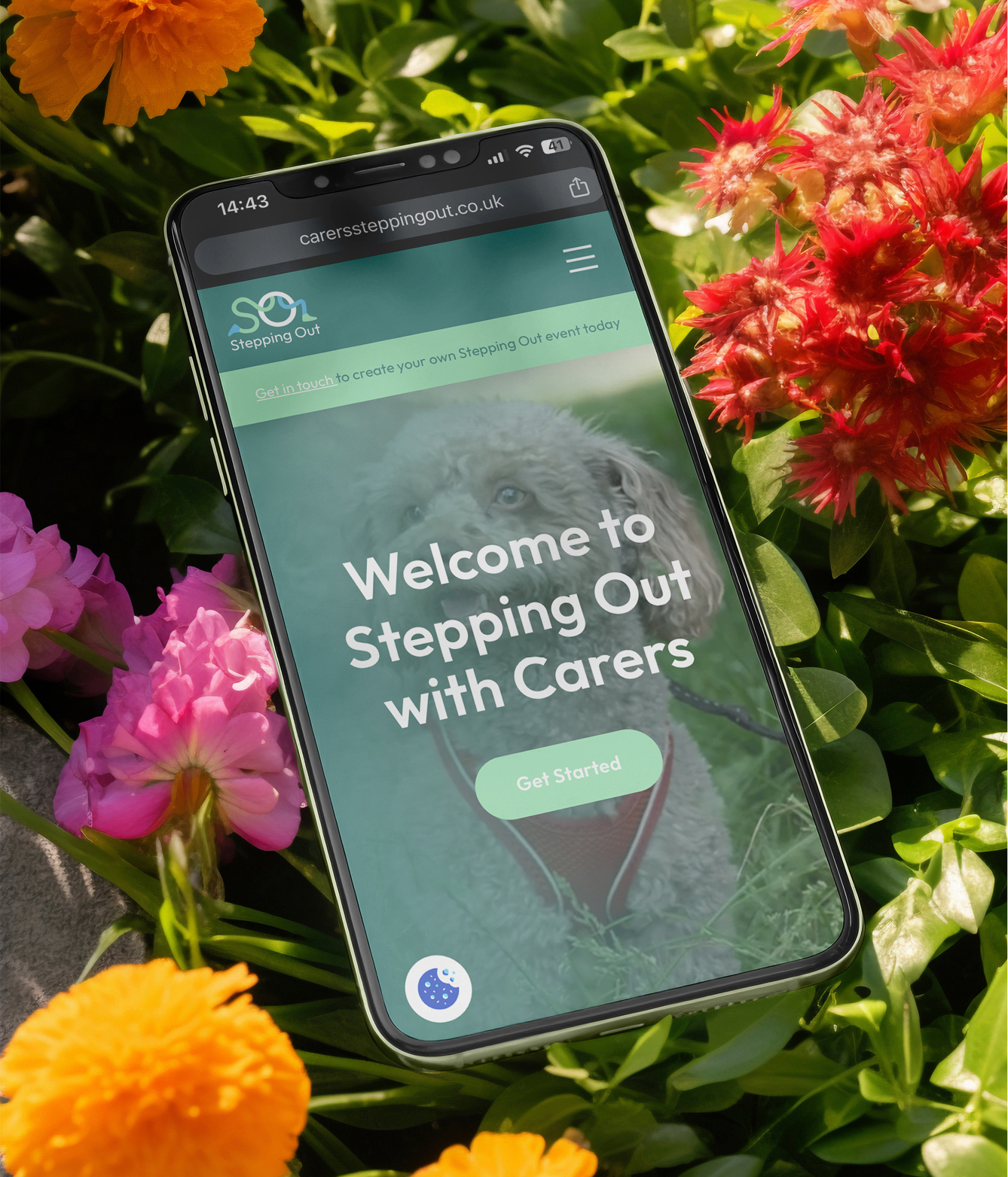 Smiling woman in a bird-patterned robe preparing coffee by a window in a modern kitchen.