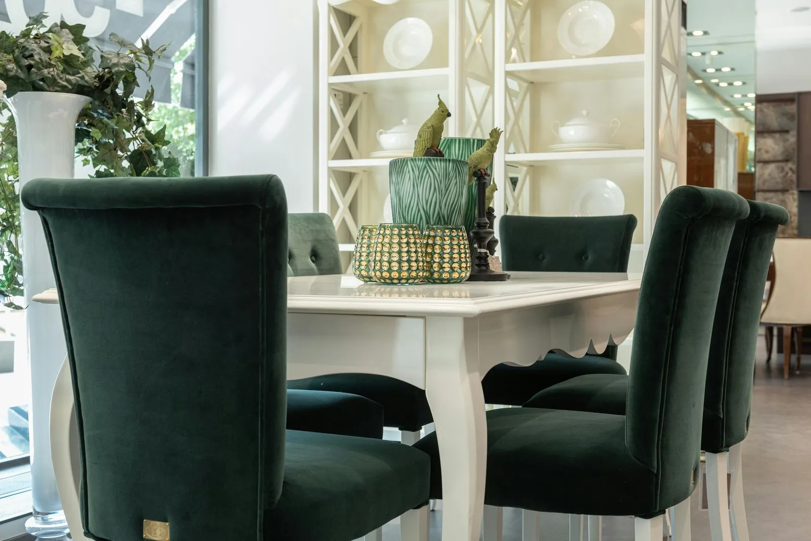 White dining table with green velvet chairs