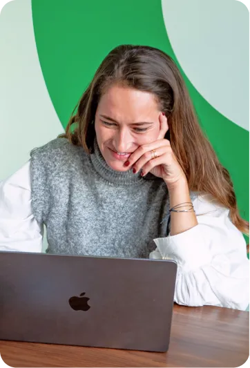 Photo d'une jeune femme souriant devant son ordinateur portable