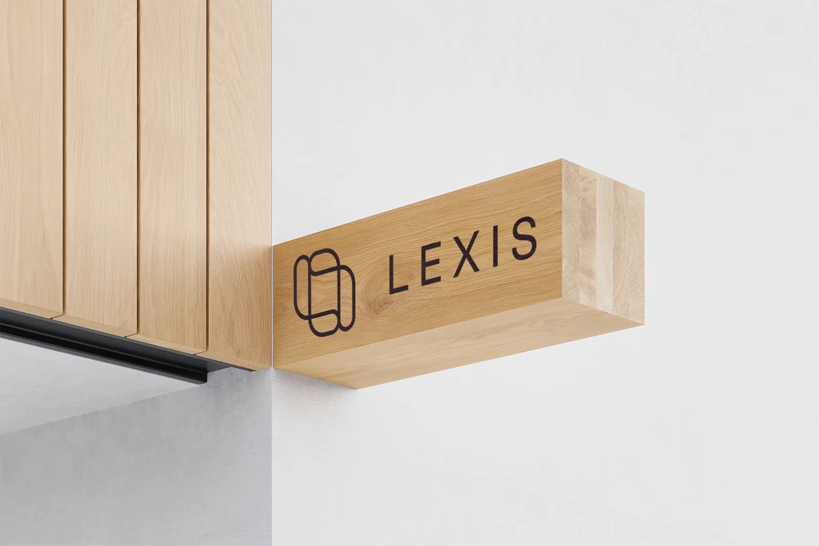 Trehvit veggmontert skilt med svart logo og teksten 'LEXIS'.