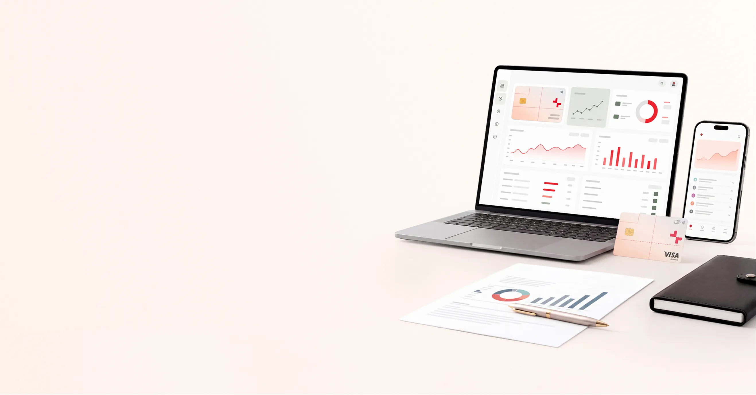 Laptop and smartphone displaying financial graphs next to a Visa business card, report, pen, and notebook.