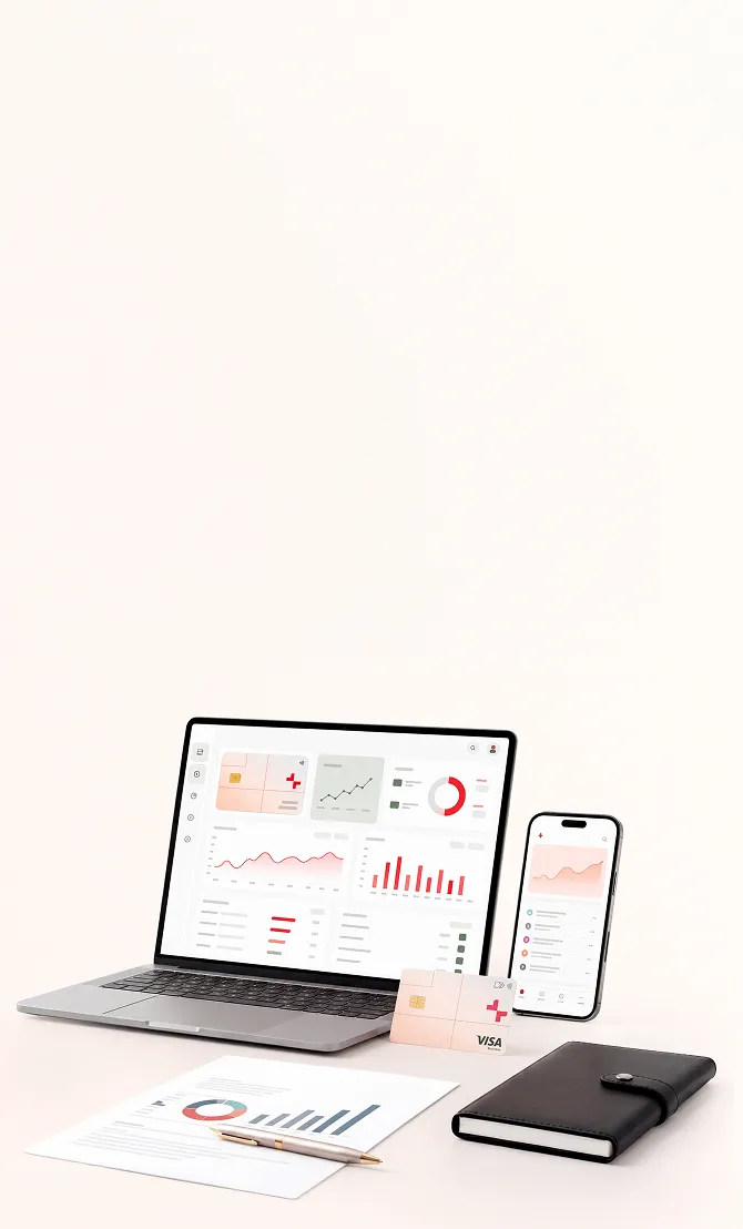 Laptop and smartphone displaying financial charts with credit card, report, pen, and black notebook on desk.