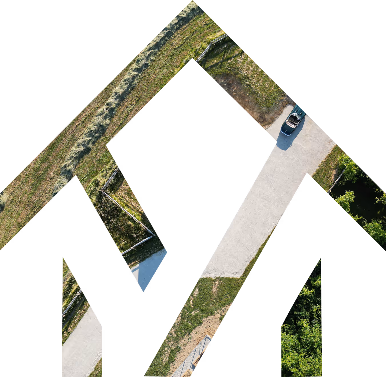 Aerial view of a black convertible car parked on a cross-shaped gravel path surrounded by green grass and trees.