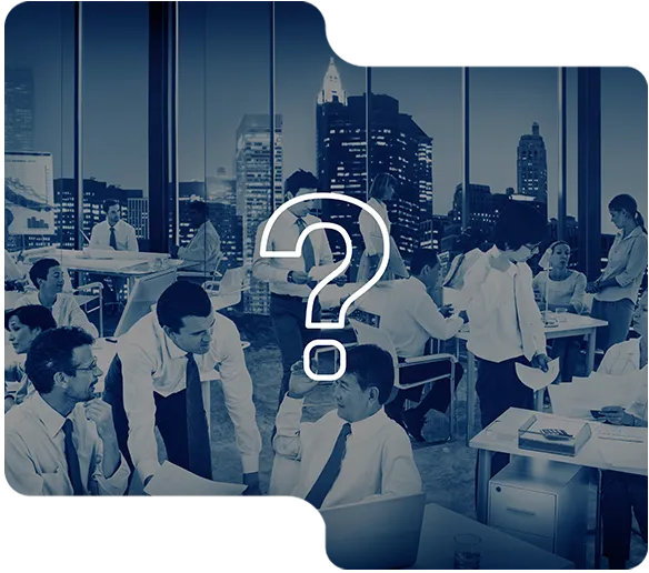 Busy office with multiple professionals engaged in work and conversation, city skyline in background.