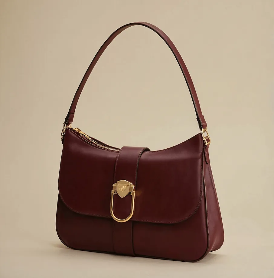 Dark burgundy leather handbag with a single shoulder strap and gold-tone clasp on front flap.