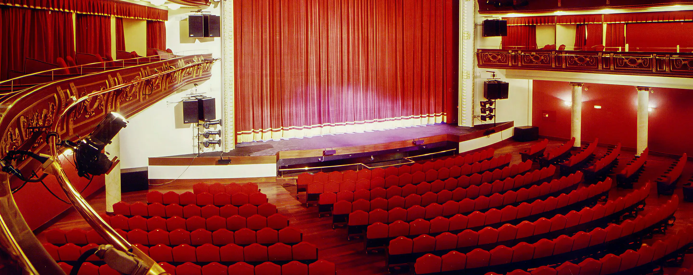 Perspektive vom ersten Balkon auf die geschwungenen Sitzreihen der Spezialanfertigung Alcalá im historischen Theaterambiente in Madrid.