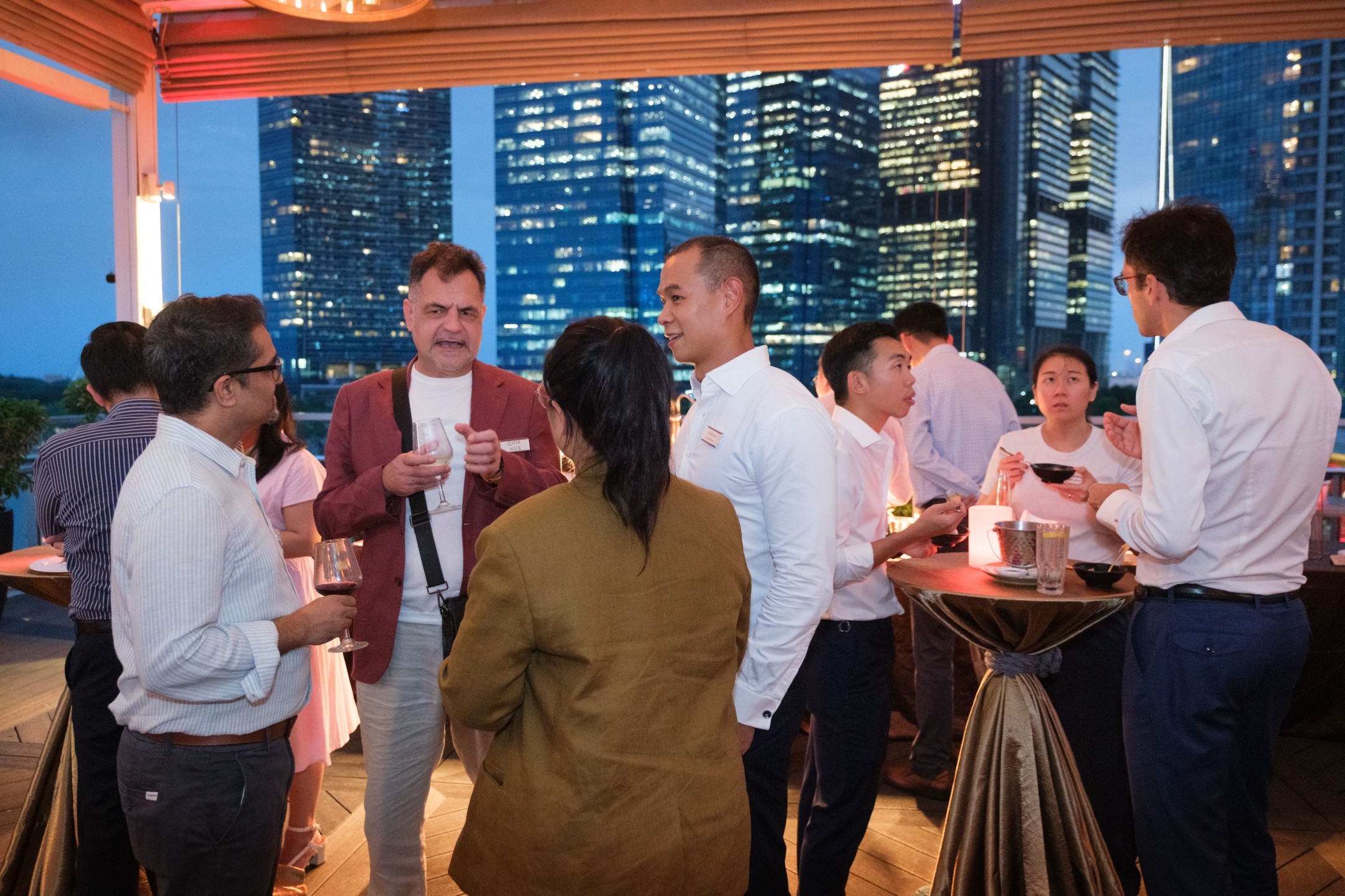 Guests in conversation, city skyline behind