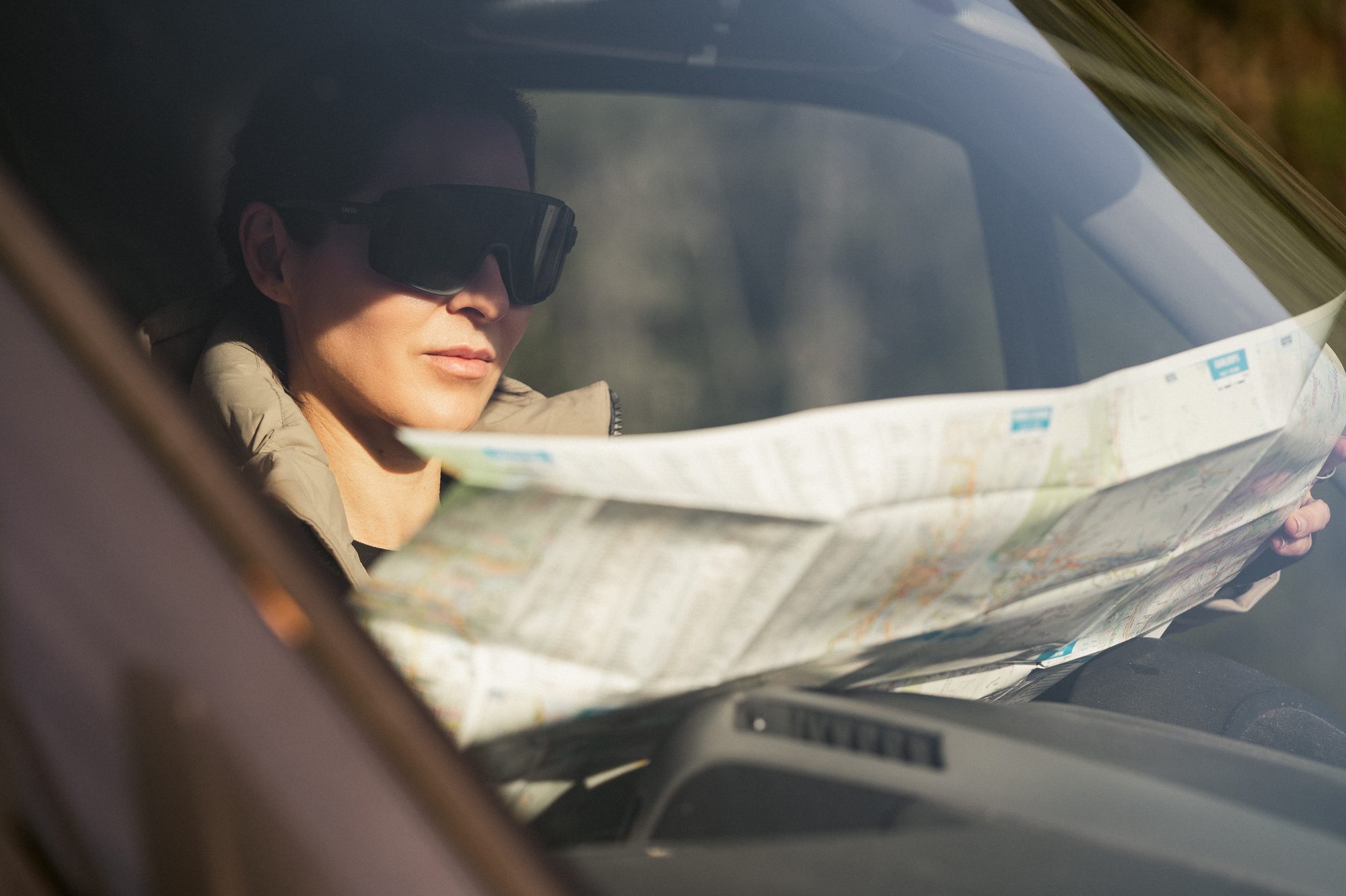 Woman reading a paper map on a road trip
