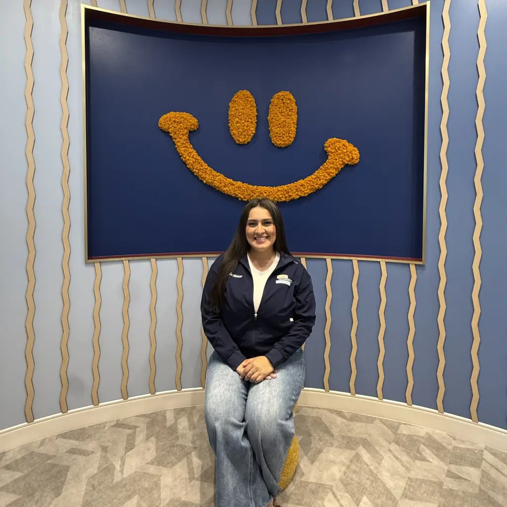 Leslie, team member at Friendly Neighborhood Orthodontist, at the Smile Corner wall