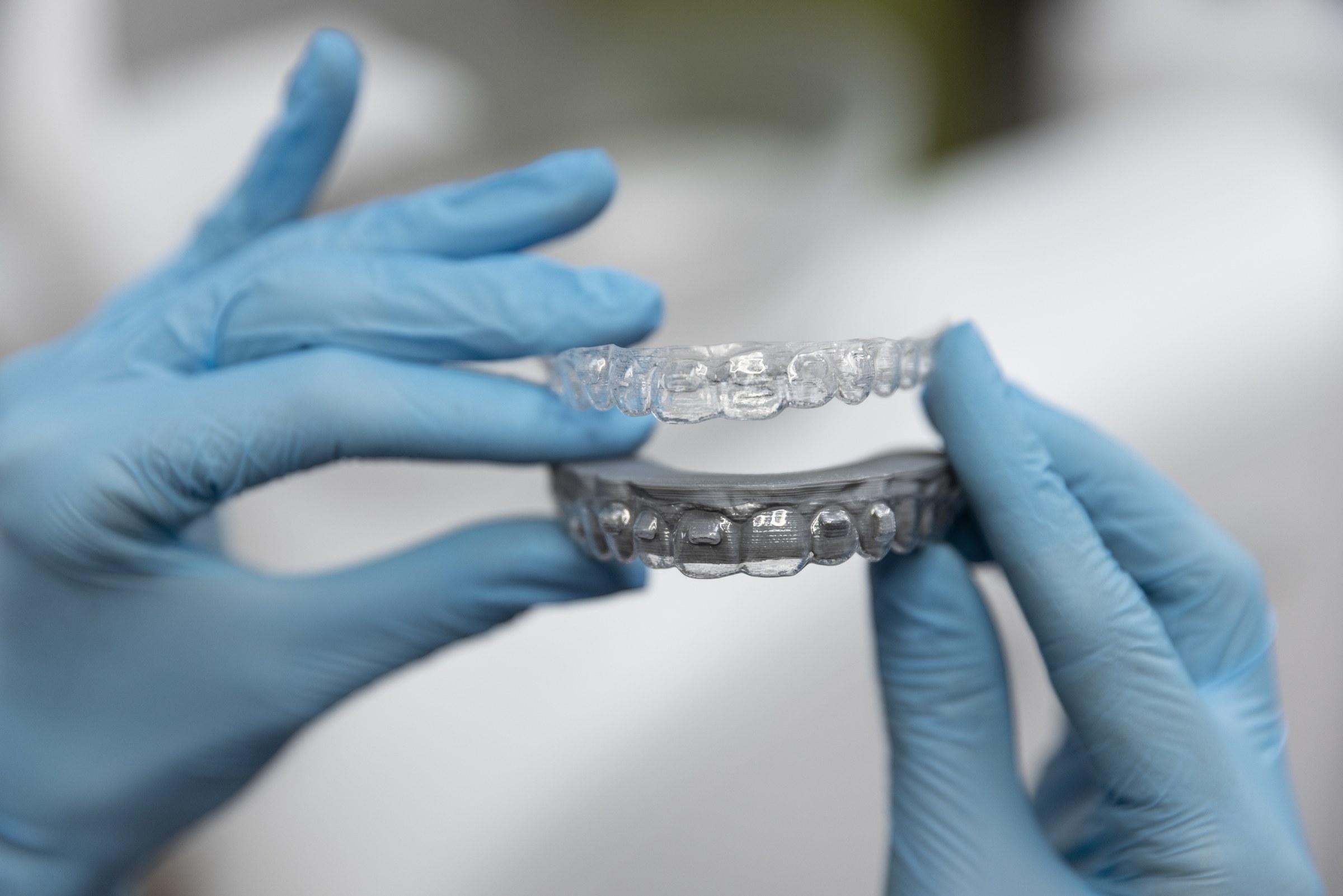 Gloved hands holding clear aligners at Friendly Neighborhood Orthodontist in La Grange, IL