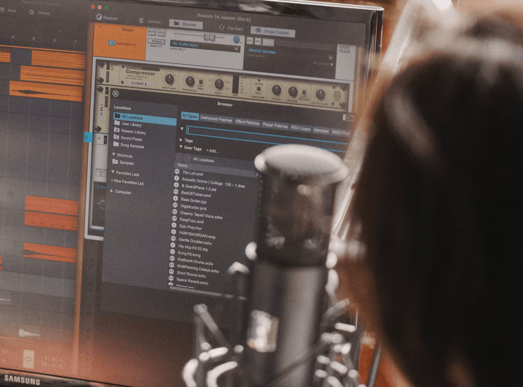 Person recording voice with a microphone in front of a music production software on a computer screen.