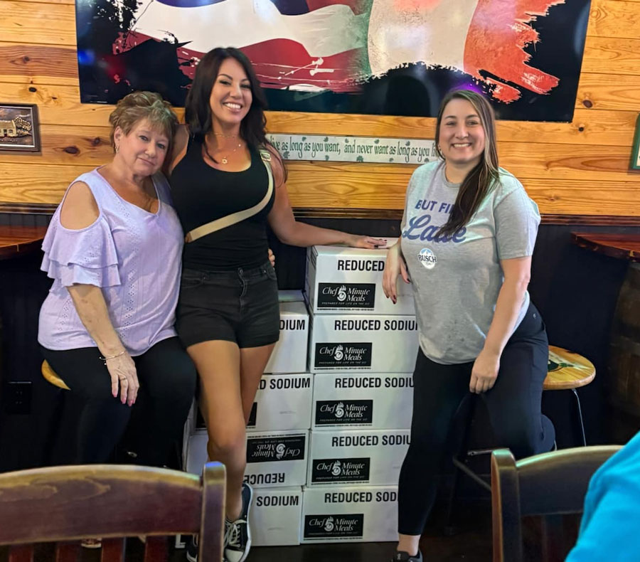 The Social Circle team members standing beside donated meal boxes during a community outreach event at a local restaurant