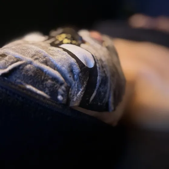 Close-up of an embroidered patch on fabric with blurred warm lighting in the background.