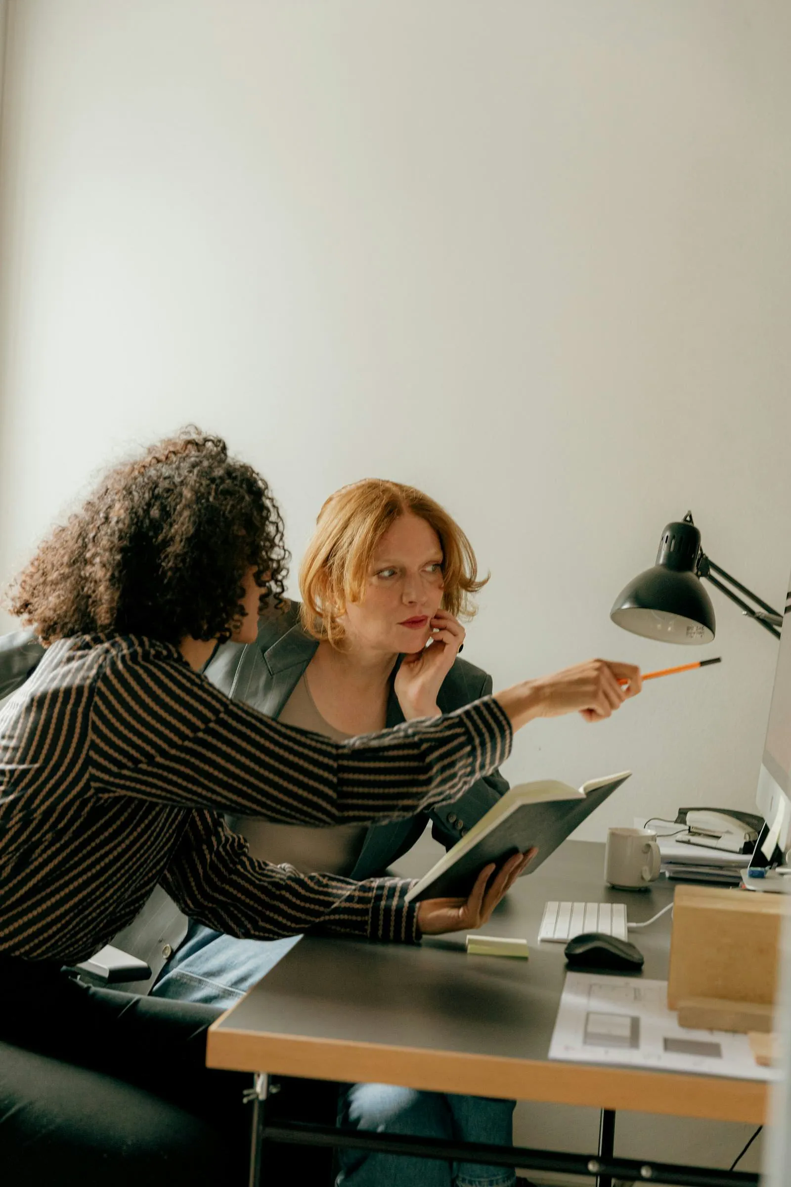 Two professionals reviewing data together at a desk, collaborating on plan decisions