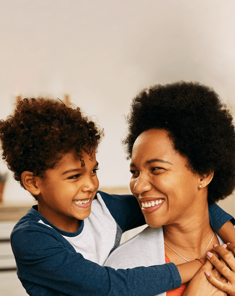 Mother and child smiling together, representing improved health outcomes and family well-being