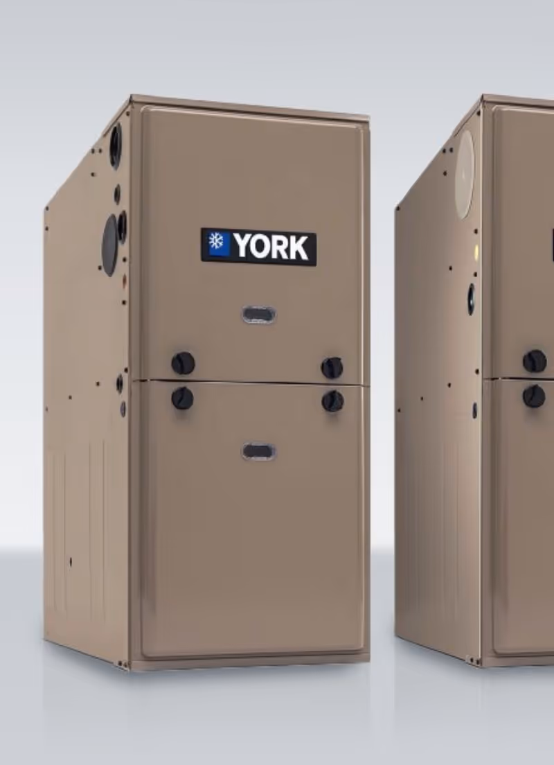 Beige YORK brand HVAC unit with black knobs and ventilation ports on side.