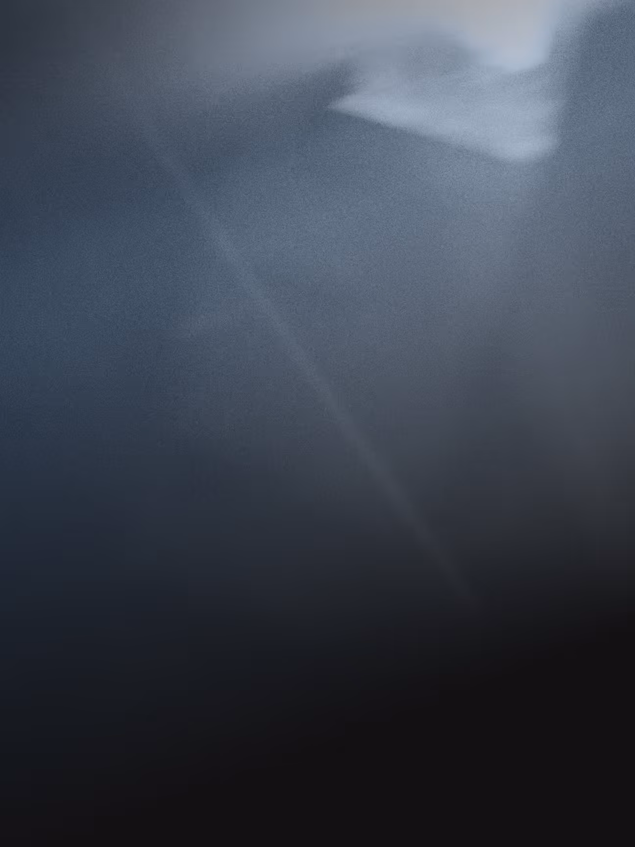 Neblige, dunkle Berglandschaft mit Lichtstrahlen durchbrechender Sonne