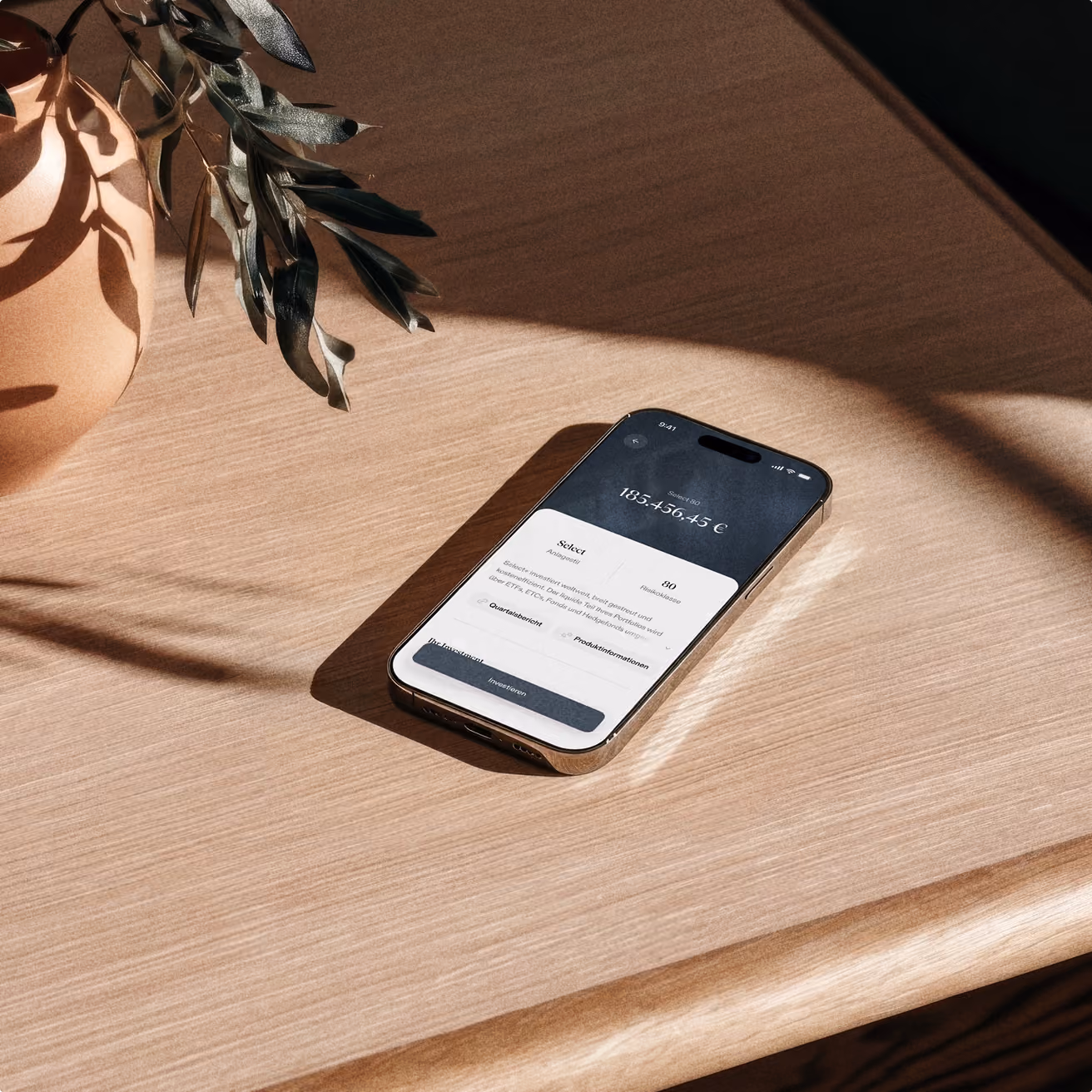 Smartphone auf Holztisch mit Pflanzen und Sonnenschatten, minimalistisches Design