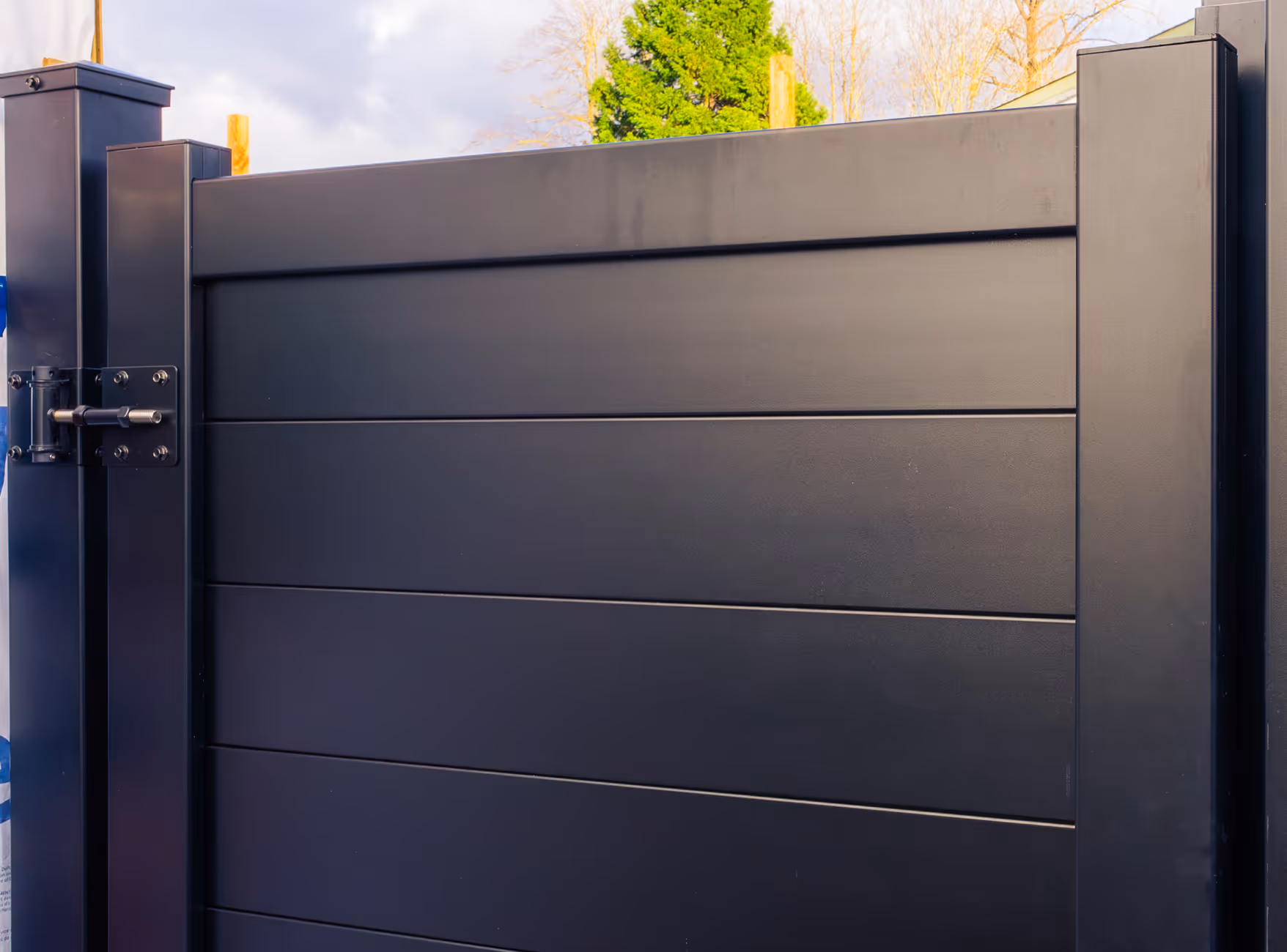 Modern black pedestrian gate with horizontal panels and a latch lock on the left side.